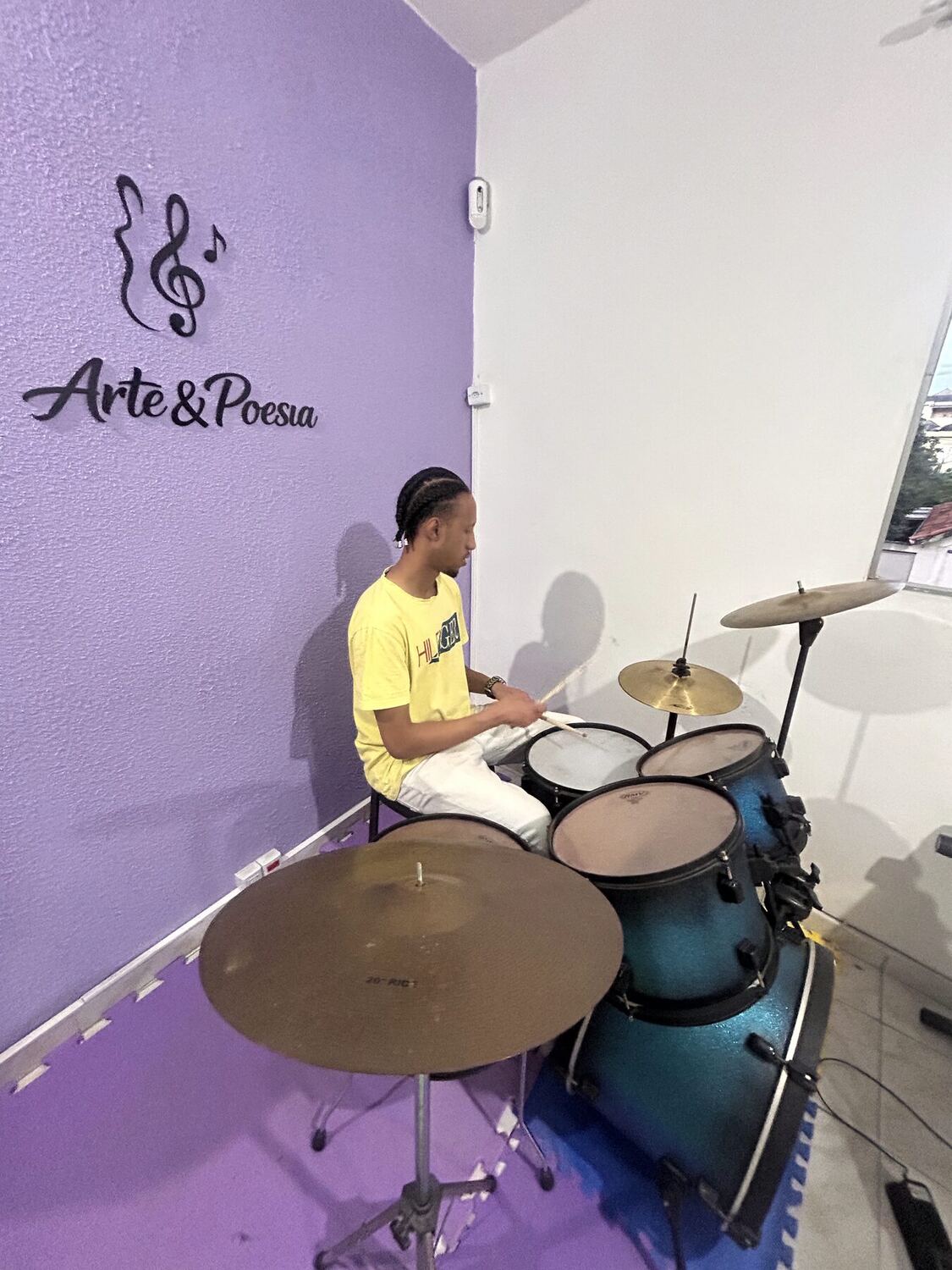Sala de bateria com a assinatura Arte & Poesia na parede