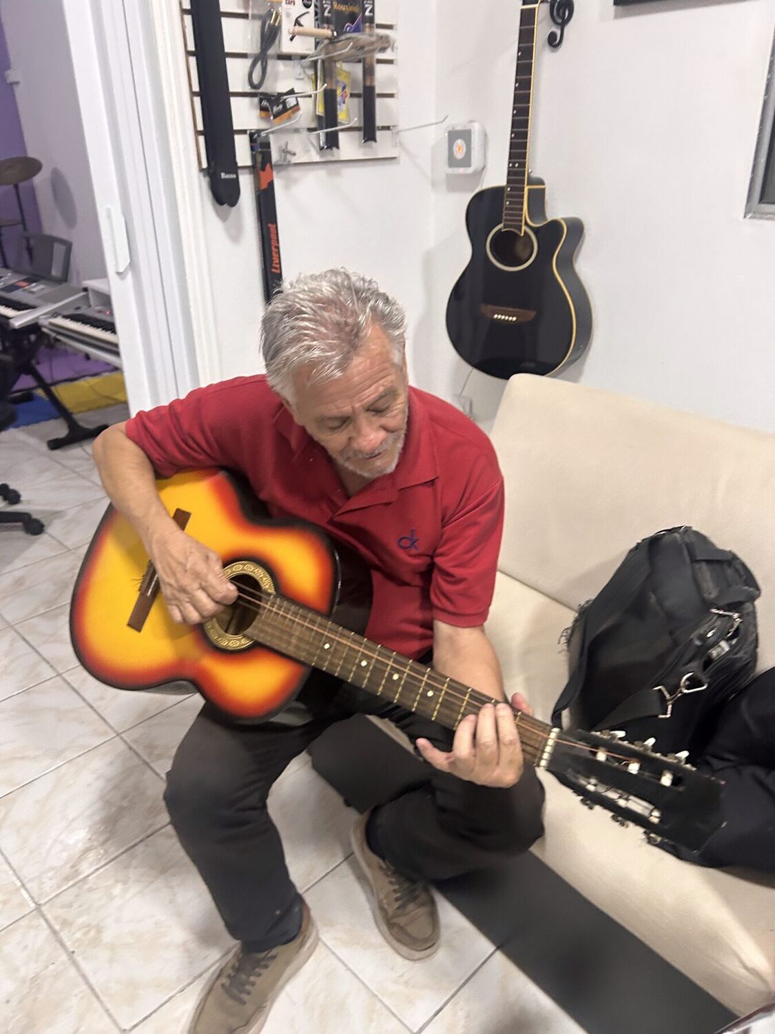 Aluno adulto tocando violão em aula na Escola Arte & Poesia