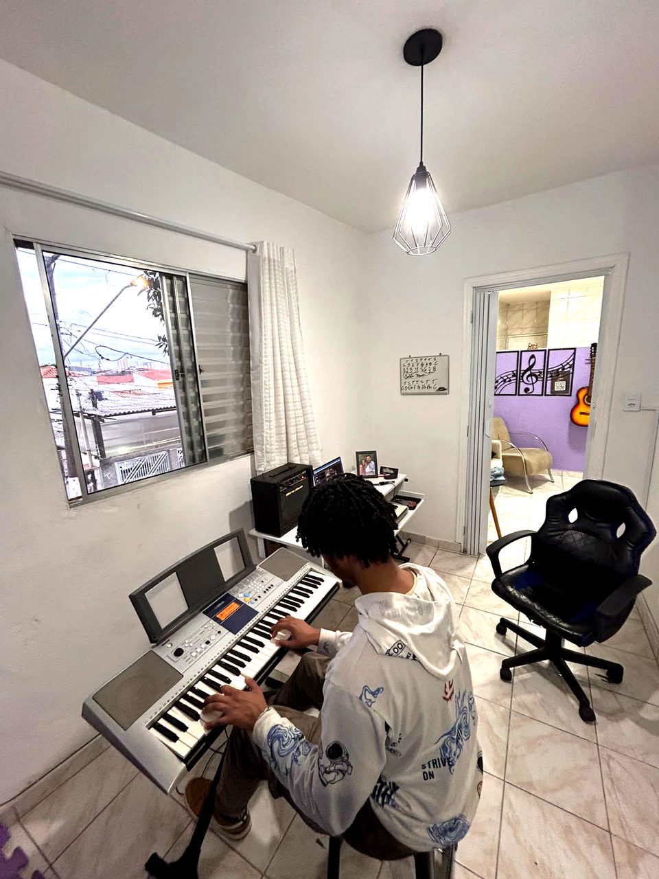 Aluno em aula de teclado na sala clara da escola